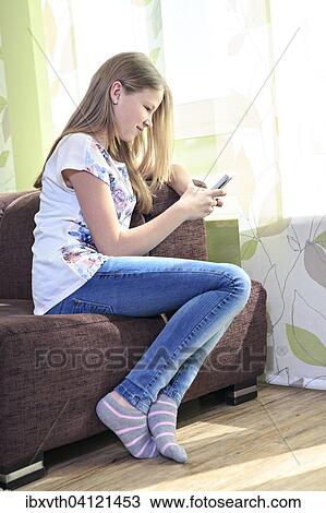 Teenage girl at home, using a cell phone View Large Photo Image Stock Image - Teenage girl at home, using a cell phone. Fotosearch
