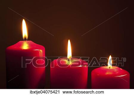 Three lit red candles View Large Photo Image Stock Image - Three lit red candles. Fotosearch