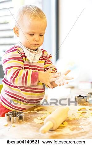 Toddler, two years, baking biscuits at Christmas time View Large Photo Image Stock Image - Toddler, two years, baking biscuits at Christmas time. Fotosearch