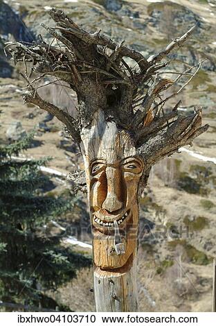 Stock Image - Tree root, with a carved face, Zermatt, Canton of Valais, Switzerland, Europe. Fotosearch