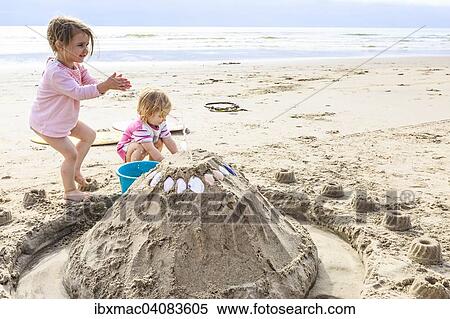 Two girls, toddlers, playing with a sand castle on the beach, Langstrand, Namibia, Africa View Large Photo Image Stock Photography - Two girls, toddlers, playing with a sand castle on the beach, Langstrand, Namibia, Africa. Fotosearch
