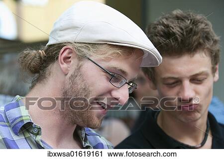 Two young men leafing through a book and enjoying the funny contents, Germany, Europe View Large Photo Image Stock Image - Two young men leafing through a book and enjoying the funny contents, Germany, Europe. Fotosearch