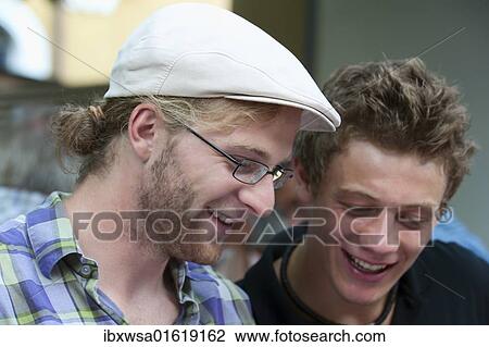 Two young men leafing through a book and enjoying the funny contents, Germany, Europe View Large Photo Image Stock Image - Two young men leafing through a book and enjoying the funny contents, Germany, Europe. Fotosearch