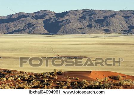 View of the sand dunes of the southern foothills of the Namib Desert and Gunsbewys Farm, Tiras Mountains at the back, Namibia, Africa View Large Photo Image Stock Image - View of the sand dunes of the southern foothills of the Namib Desert and Gunsbewys Farm, Tiras Mountains at the back, Namibia, Africa. Fotosearch