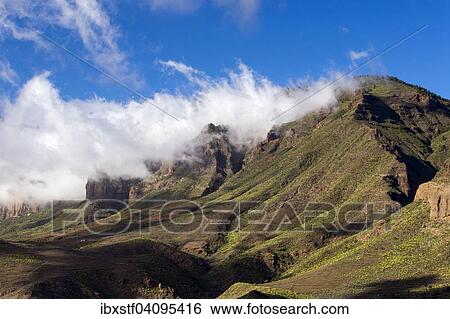 Wispy clouds over a mountain ridge, Santa Lucia de Tirajana, Gran Canaria, Canary Islands, Spain, Europe View Large Photo Image Stock Photograph - Wispy clouds over a mountain ridge, Santa Lucia de Tirajana, Gran Canaria, Canary Islands, Spain, Europe. Fotosearch