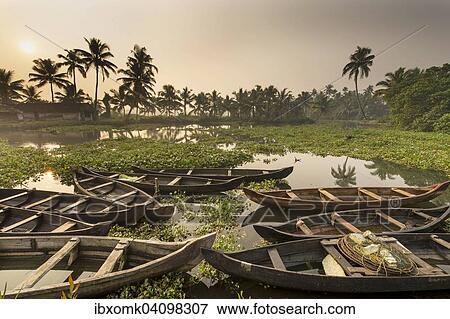 Stock Photo - Wooden barges, some filled with water, backwaters, Ernakulam District, waterway network in the hinterland of the Malabar Coast, Kerala, India, Asia. Fotosearch