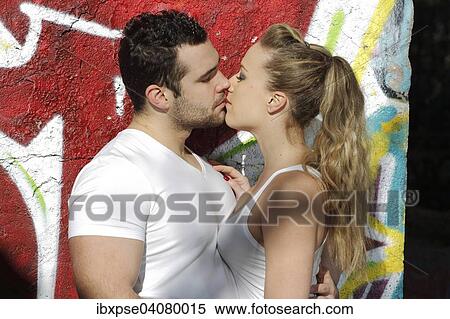 Stock Photography - Young couple kissing in ruined building covered in graffiti. Fotosearch