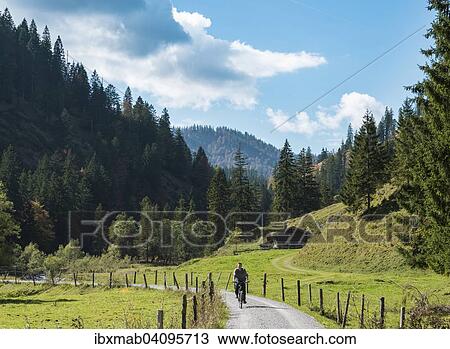 Stock Image - Young man riding a bicycle, mountain landscape, Valepptal, Spitzingsee, Bavaria, Germany, Europe. Fotosearch
