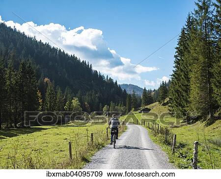 Stock Photo - Young man riding a bicycle, mountain landscape, Valepptal, Spitzingsee, Bavaria, Germany, Europe. Fotosearch