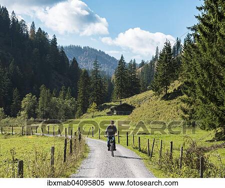 Young man riding a bicycle, mountain landscape, Valepptal, Spitzingsee, Bavaria, Germany, Europe View Large Photo Image Stock Photography - Young man riding a bicycle, mountain landscape, Valepptal, Spitzingsee, Bavaria, Germany, Europe. Fotosearch