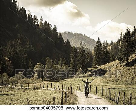 Young man riding a bicycle without his hands, mountain landscape, Valepptal, Spitzingsee, Bavaria, Germany, Europe View Large Photo Image Stock Photo - Young man riding a bicycle without his hands, mountain landscape, Valepptal, Spitzingsee, Bavaria, Germany, Europe. Fotosearch