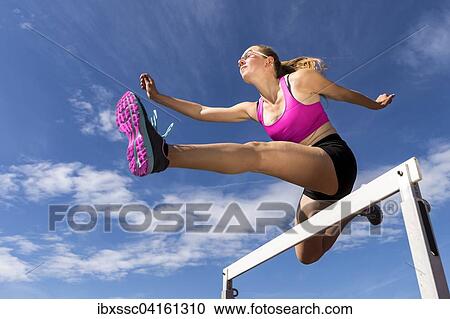 Young woman, 18 years, hurdling View Large Photo Image Stock Image - Young woman, 18 years, hurdling. Fotosearch
