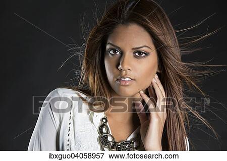 Stock Photo - Young woman, dark-haired with white blouse, fashion, lifestyle, portrait. Fotosearch