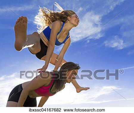 Young women, 18 and 20 years, leapfrogging View Large Photo Image Stock Image - Young women, 18 and 20 years, leapfrogging. Fotosearch
