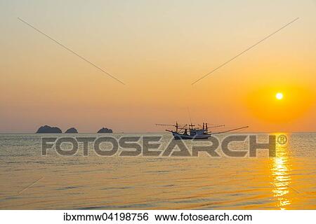 Stock Photograph - Boat in the sea at sunset in front of small islands, Koh Samui, Gulf of Thailand, Thailand, Asia. Fotosearch