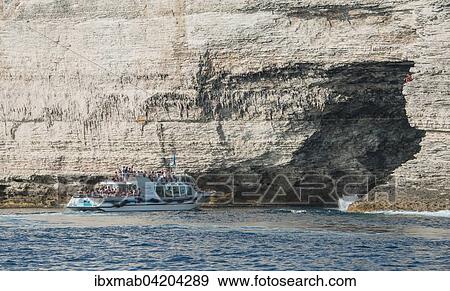 Stock Photo - Excursion boat visiting cave in chalk cliffs, Bonifacio, Corsica, France, Europe. Fotosearch