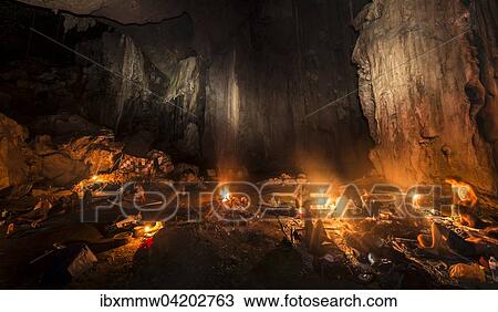 Stock Image - Hikers, tourists sleeping in a cave with a campfire, Kuala Tahan, Taman Negara National Park, Malaysia, Asia. Fotosearch