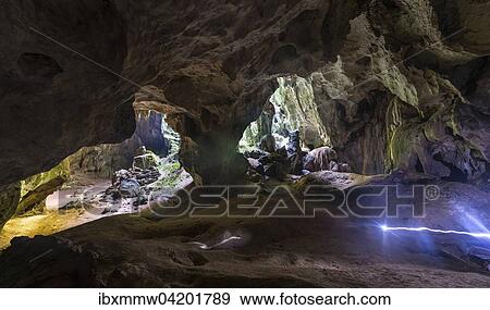 Stock Photo - Hikers walking through a large cave, light trails, stalactite cave, King and Queen cave, Taman Negara National Park, Jerantut, Pahang, Malaysia, Asia. Fotosearch