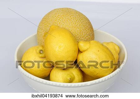 Picture - Lemons and cantaloupe melon in fruit bowl. Fotosearch