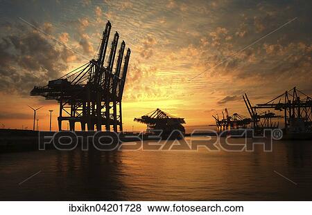 Stock Photo - Loading cranes at sunset in the Waltershofer Harbor, Hamburg, Germany, Europe. Fotosearch