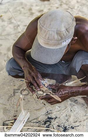 Picture - Man of the Orang Asil starting a fire, Taman Negara, Malaysia, Asia. Fotosearch
