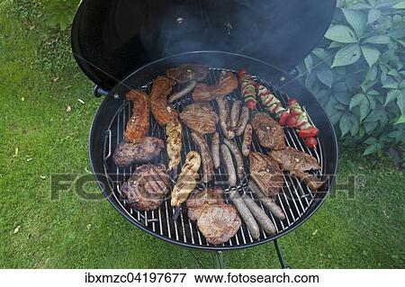Meat, sausages and vegetarian skewers on a charcoal barbecue View Large Photo Image Stock Photo - Meat, sausages and vegetarian skewers on a charcoal barbecue. Fotosearch