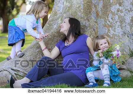 Stock Photograph - Pregnant woman in the park with her daughters, Tintenpalast, Windhoek, Namibia, Africa. Fotosearch