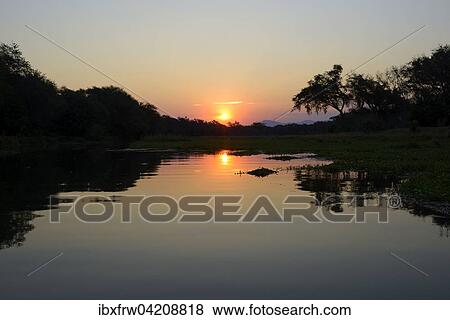 Sunset at a branch of the Zambezi river, Lower Zambezi National Park, Zambia, Africa View Large Photo Image Stock Photo - Sunset at a branch of the Zambezi river, Lower Zambezi National Park, Zambia, Africa. Fotosearch