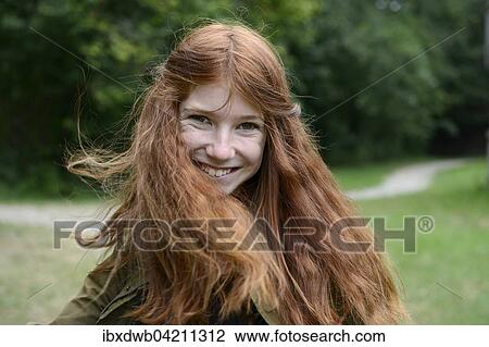 Stock Image - Teenage girl with long red hair, flicking her hair, Germany, Europe. Fotosearch