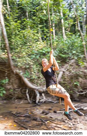 Young Woman Swinging On A Vine In The Jungle Tropical Rain Forest Taman Negara Malaysia Asia Stock Image