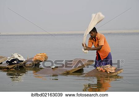 A Dhobi wala, a man of the laundry cast, doing laundry at the ghats along the holy river Ganges, Varanasi, Uttar Pradesh, India, Asia View Large Photo Image Stock Photo - A Dhobi wala, a man of the laundry cast, doing laundry at the ghats along the holy river Ganges, Varanasi, Uttar Pradesh, India, Asia. Fotosearch