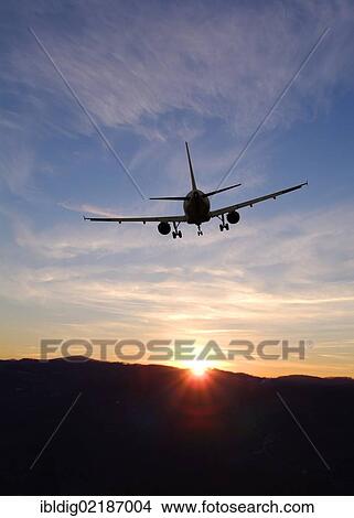 Picture - Airplane taking off into sunset. Fotosearch