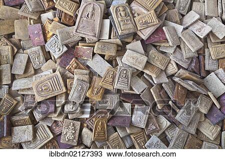Stock Image - Amulets depicting the Buddhas or venerable monks worn by many Thai people on display at a market, Lopburi, Thailand, Asia. Fotosearch