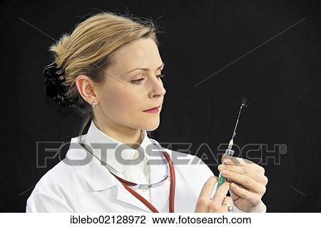 Assistant physician, young doctor preparing a syringe View Large Photo Image Stock Image - Assistant physician, young doctor preparing a syringe. Fotosearch