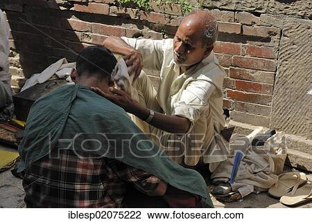 Barber cutting a man's hair on the street, Kathmandu, Nepal, Asia View Large Photo Image Stock Image - Barber cutting a man's hair on the street, Kathmandu, Nepal, Asia. Fotosearch