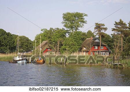 Boats and residential houses on the Prerow river near Prerow, Darss-Zingst, Western Pomerania Lagoon Area National Park, Mecklenburg-Western Pomerania, Baltic Sea, Germany, Europe View Large Photo Image Stock Photography - Boats and residential houses on the Prerow river near Prerow, Darss-Zingst, Western Pomerania Lagoon Area National Park, Mecklenburg-Western Pomerania, Baltic Sea, Germany, Europe. Fotosearch