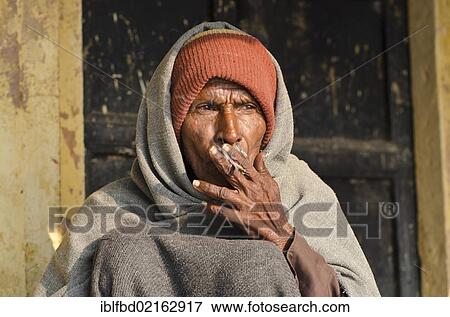 Stock Photo - Boot wala waiting for customers, smoking, Varanasi, Uttar Pradesh, India, Asia. Fotosearch