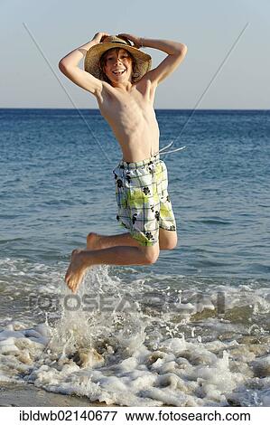 Boy jumping for joy on a beach by the sea View Large Photo Image Stock Photo - Boy jumping for joy on a beach by the sea. Fotosearch