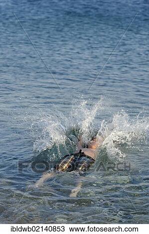 Stock Image - Boy jumping into the sea. Fotosearch