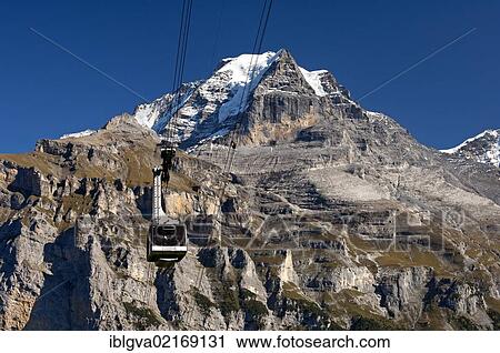 Stock Image - Cabin of the Schilthorn cable car in front of the Jungfrau massif, Muerren, Bernese Oberland, Switzerland, Europe. Fotosearch