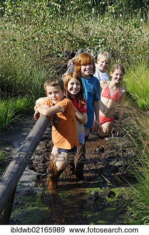 Stock Photo - Children smeared with mud, mud bath in the Sterntaler Filze, moorland, peat fields in Bad Feilnbach, Upper Bavaria, Bavaria, Germany, Europe. Fotosearch