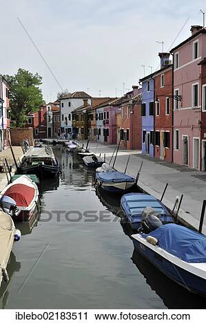 Stock Image - Colourful painted houses, boats in the canal of Burano, Burano Island in the lagoon of Venice, Italy, Europe. Fotosearch