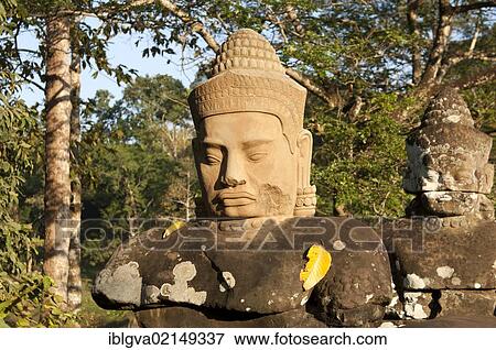 Copy of the head of a god with almond-shaped eyes and a conical headdress at the entrance to the South Gate of Angkor Thom, Siem Reap, Cambodia, Southeast Asia, Asia View Large Photo Image Stock Photo - Copy of the head of a god with almond-shaped eyes and a conical headdress at the entrance to the South Gate of Angkor Thom, Siem Reap, Cambodia, Southeast Asia, Asia. Fotosearch