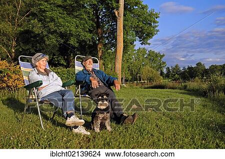Picture - Couple with a miniature schnauzer at a camping site, Villars-les-Dombes, Rhone-Alpes, Ain, France, Europe. Fotosearch