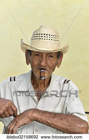 Stock Image - Cuban man smoking a cigar, portrait, Trinidad, Cuba, Greater Antilles, Caribbean, Central America, America, North America. Fotosearch