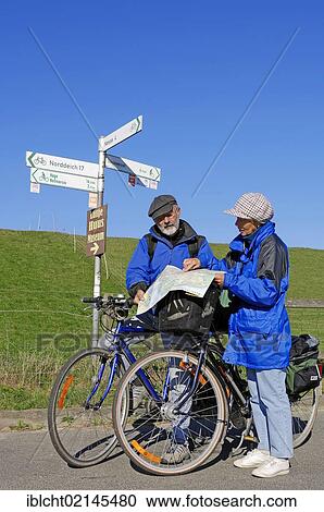 Cyclists reading a map, bike path on a dyke near Nesse, East Frisia, Lower Saxony, Germany, Europe View Large Photo Image Stock Image - Cyclists reading a map, bike path on a dyke near Nesse, East Frisia, Lower Saxony, Germany, Europe. Fotosearch
