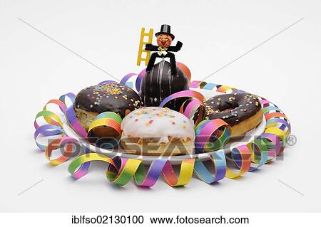 Doughnuts and glaced filled doughnuts on a plate with New Year's decorations, a garland and a chimney sweep View Large Photo Image Stock Image - Doughnuts and glaced filled doughnuts on a plate with New Year's decorations, a garland and a chimney sweep. Fotosearch