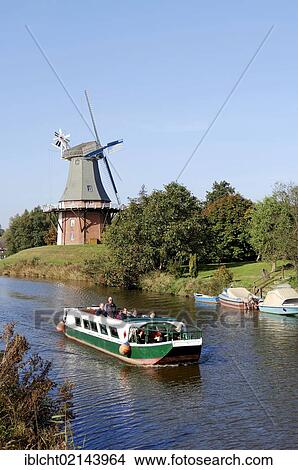 Picture - Excursion boat and a windmill, one of the twin mills of Greetsiel, East Frisia, Lower Saxony, Germany, Europe. Fotosearch