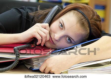 Exhausted office worker with telephone handset resting head on files and folders View Large Photo Image Stock Image - Exhausted office worker with telephone handset resting head on files and folders. Fotosearch