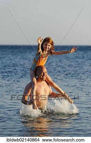 Father and daughter splashing around in the sea View Large Photo Image Picture - Father and daughter splashing around in the sea. Fotosearch